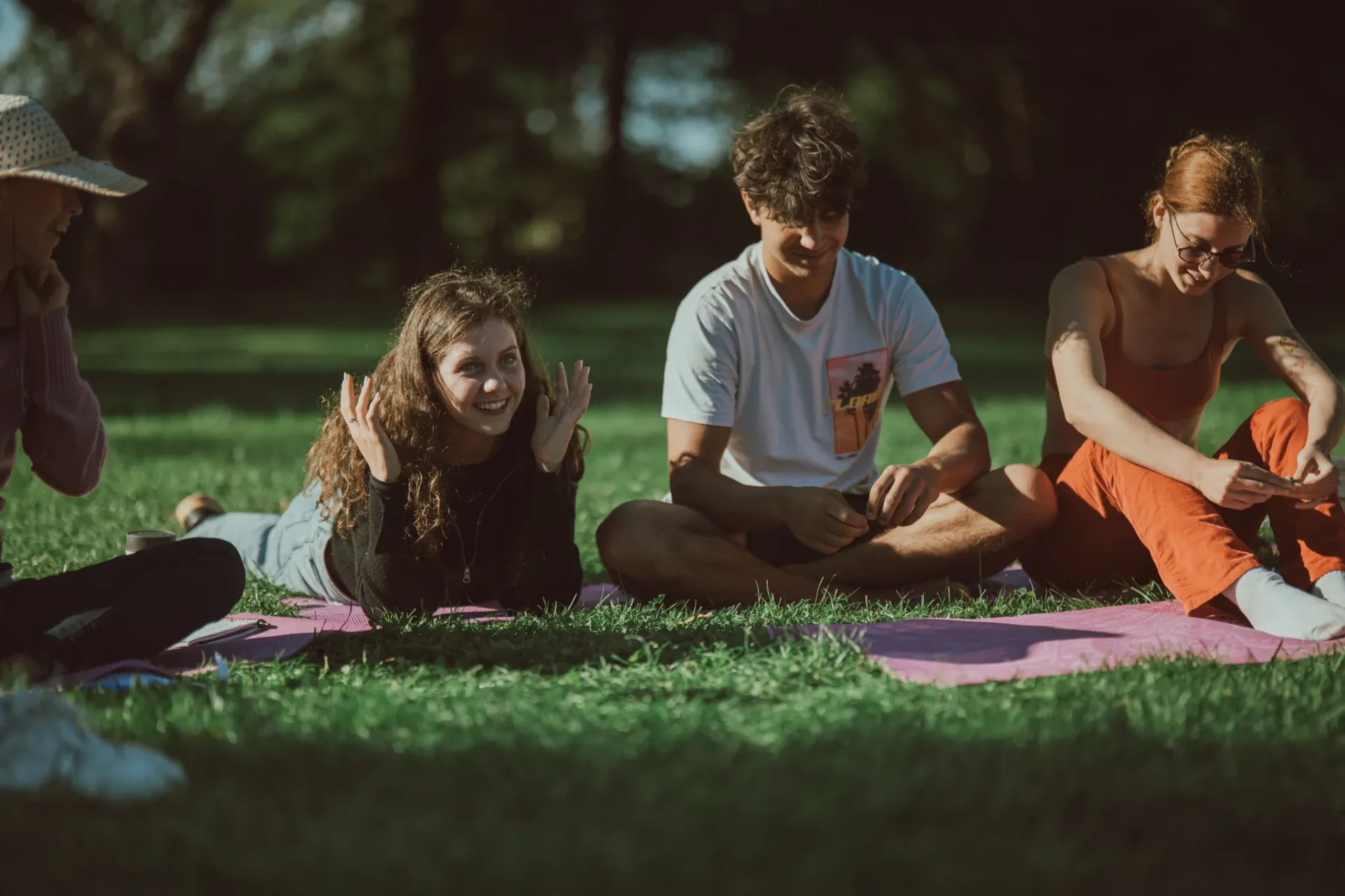 Young people relaxing and laughing together in a sunlit park